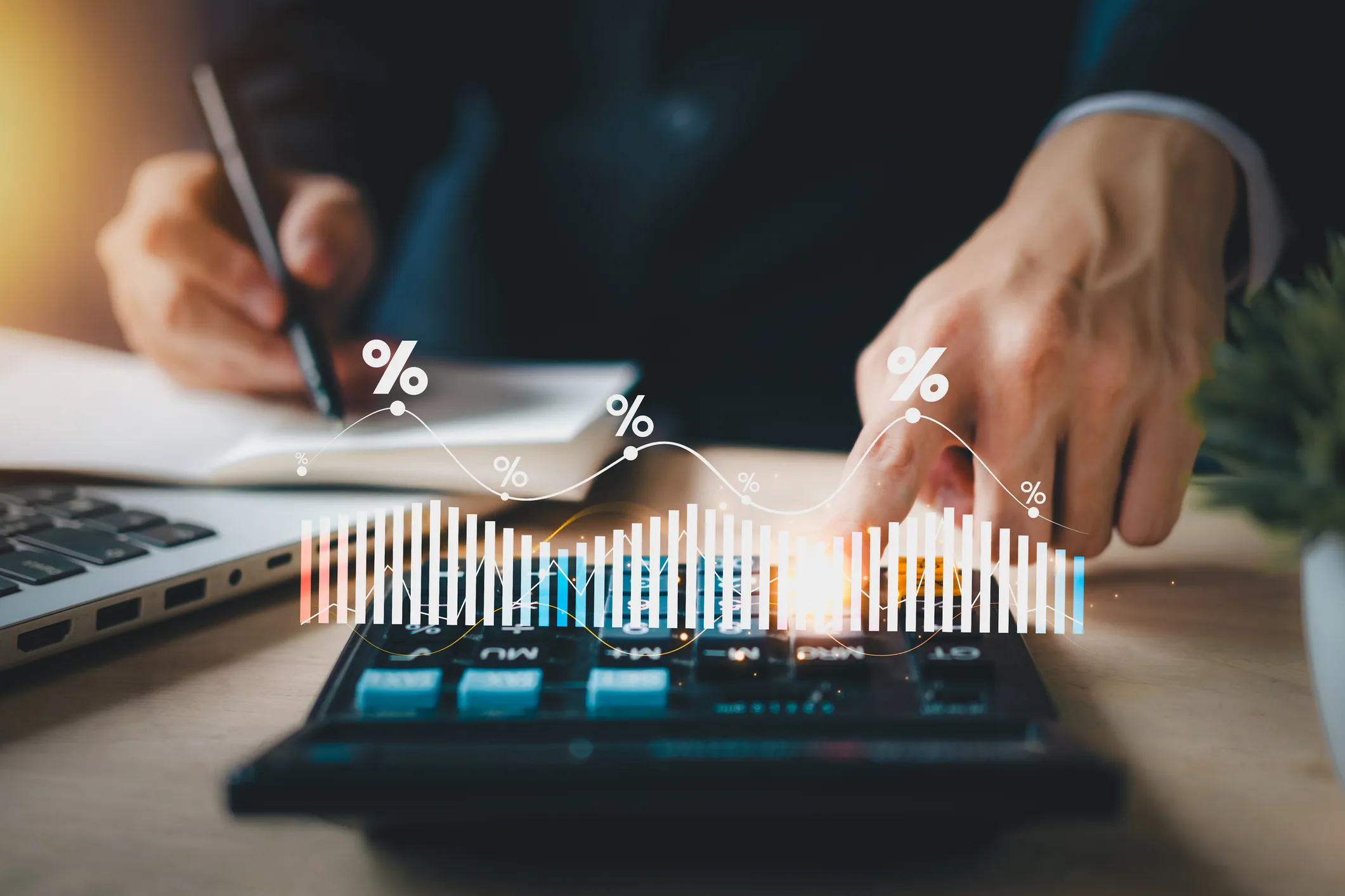 A business owner working through costs on a calculator at a desk